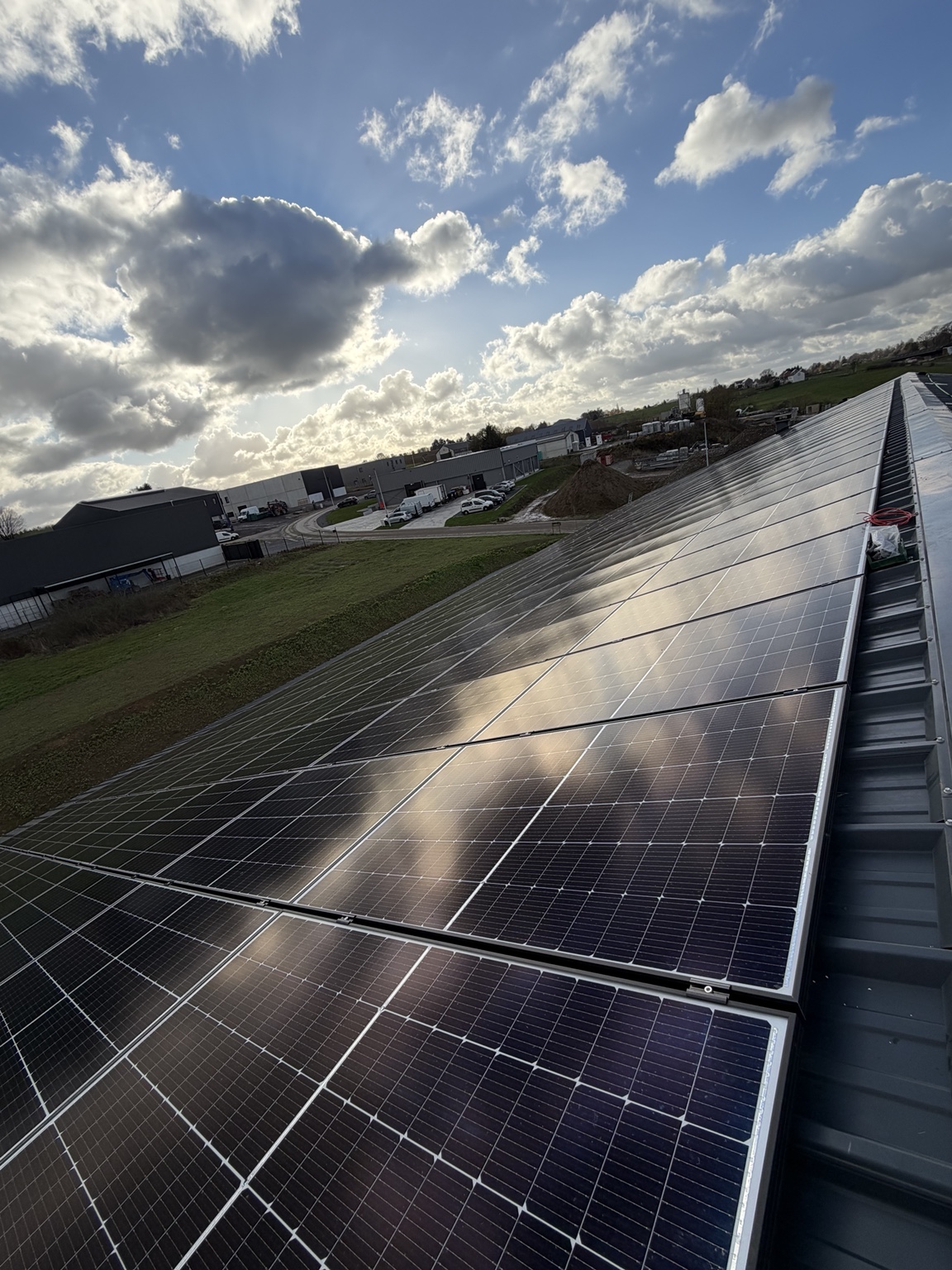 224 panneaux photovoltaïques sur toiture, avec les reflets du soleil — réalisation en collaboration avec SV Elec
